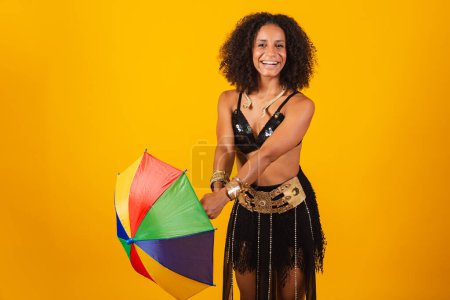 Photo for Beautiful black Brazilian woman, in Cleopatra carnival clothes, holding colorful umbrella. - Royalty Free Image