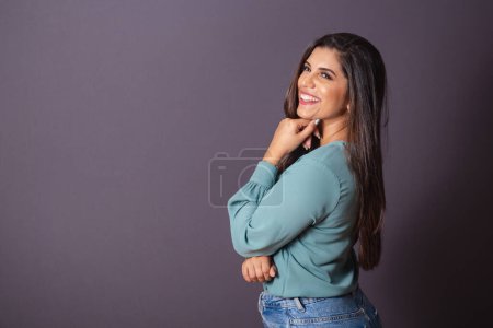 Foto de Foto horizontal. Hermosa mujer brasileña, con ropa casual, Jeans y camisa verde. posando para la foto. - Imagen libre de derechos