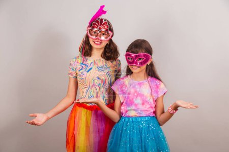 Téléchargez les photos : Deux enfants brésiliens, filles, vêtus de vêtements de carnaval, à bras ouverts, bienvenue. - en image libre de droit