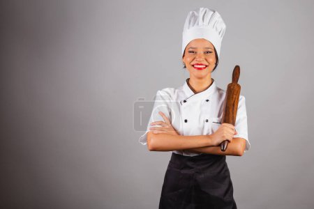 Photo for Head chef, Brazilian cook, from the Northeast, holding a wooden rolling pin for preparing bread and pasta. - Royalty Free Image