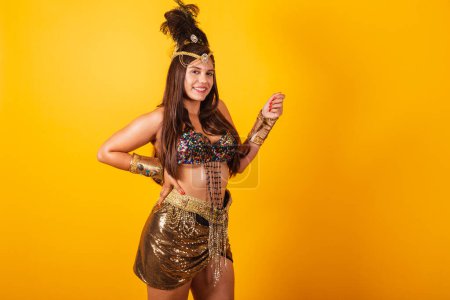Foto de Hermosa mujer brasileña en ropa de carnaval de oro, con los brazos abiertos, posando para las fotos. - Imagen libre de derechos