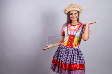 Photo for Brazilian woman wearing country clothes, So Joo party, Junina party. Open arms welcome. welcoming - Royalty Free Image