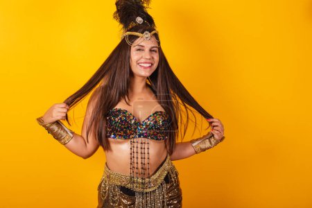Téléchargez les photos : Belle femme brésilienne en vêtements de carnaval d'or, tenant les cheveux. - en image libre de droit