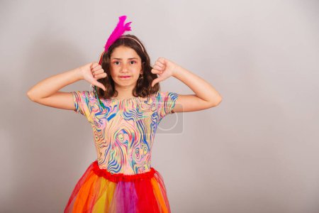 Téléchargez les photos : Enfant brésilien, fille, habillée en tenue de carnaval, signe de dégoût avec les doigts. - en image libre de droit