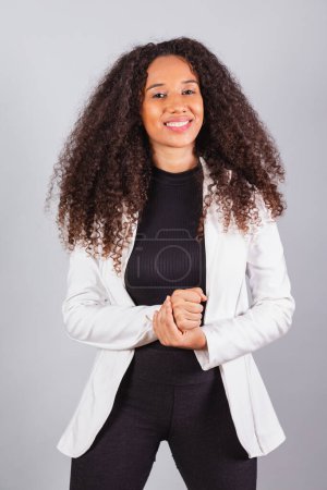 Photo for Vertical photo, beautiful black Brazilian woman, businesswoman, wearing white suit, smiling, optimistic. - Royalty Free Image