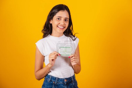Photo for Beautiful brazilian woman holding voter registration card. - Royalty Free Image