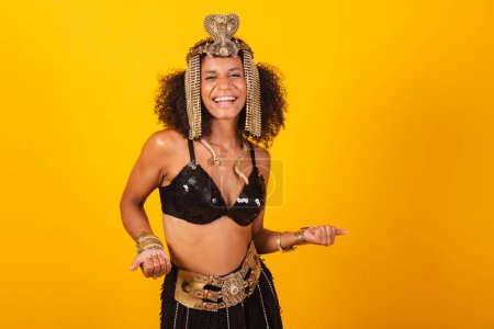 Photo for Beautiful Brazilian black woman, in Cleopatra carnival clothes, inviting with hands. - Royalty Free Image
