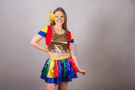 Foto de Mujer rubia brasileña, vestida con ropa frevo, máscara de carnaval y mano en la cintura. - Imagen libre de derechos