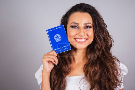 Foto de Mujer brasileña, cabello castaño, tarjeta de trabajo y seguridad social. Trabajos formales. - Imagen libre de derechos