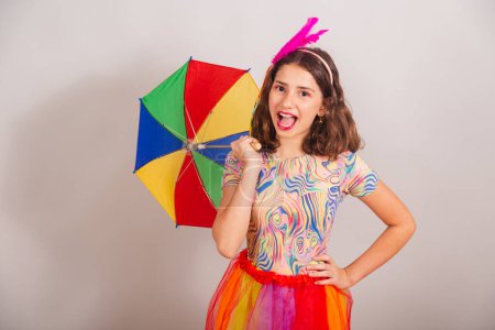 Photo for Brazilian child, girl, dressed in carnival outfit, dancing with frevo umbrella. - Royalty Free Image
