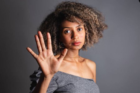 Schöne schwarze Brasilianerin posiert auf grauem Studiohintergrund 