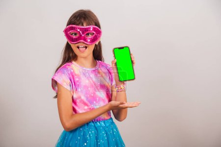 Foto de Hermosa chica brasileña, niña, vestida para el carnaval en Brasil. presentación de smartphone con pantalla Chroma verde. - Imagen libre de derechos