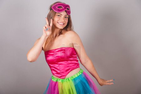 Téléchargez les photos : Femme blonde brésilienne vêtue de vêtements de carnaval rose. masque, pose pour photo, paix et amour. - en image libre de droit