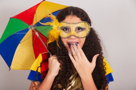 Foto de Jovencita adolescente, brasileña, con ropa frevo, carnaval. sosteniendo paraguas frevo. increíble e increíble. - Imagen libre de derechos