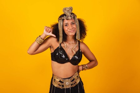 Téléchargez les photos : Belle femme brésilienne noire, en vêtements de carnaval Cleopatra, pouce baissé, négatif. - en image libre de droit