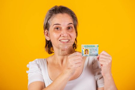 Photo for Adult Brazilian woman holding driver's license. - Royalty Free Image