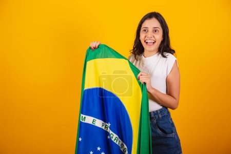 Téléchargez les photos : Belle femme brésilienne célébrant avec drapeau brésilien. - en image libre de droit