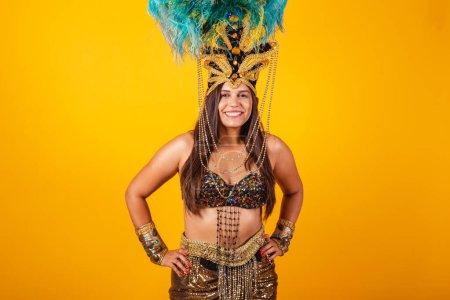 Photo for Beautiful Brazilian woman in golden carnival clothes, wearing carnival dancer feather crown. - Royalty Free Image