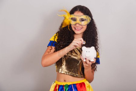 Foto de Jovencita adolescente, brasileña, con ropa frevo, carnaval. con alcancía y moneda, foto de primer plano. - Imagen libre de derechos