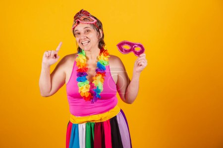 Foto de Mujer adulta en ropa de carnaval sonriendo a la cámara con la celebración de la máscara de carnaval. bailando - Imagen libre de derechos