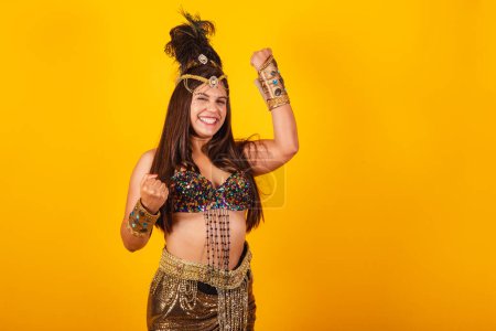 Foto de Hermosa mujer brasileña en ropa de carnaval de oro, comemo - Imagen libre de derechos