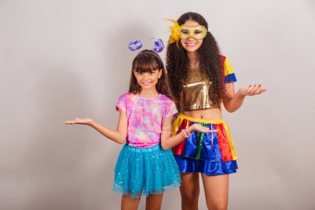 Foto de Dos amigas brasileñas, vestidas con ropa de carnaval. Abran los brazos. - Imagen libre de derechos