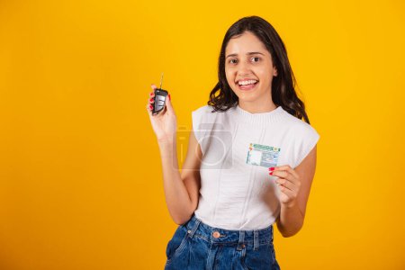 Photo for Beautiful brazilian woman holding car key and driving document. - Royalty Free Image