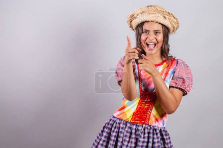 Photo for Brazilian woman wearing country clothes, So Joo party, Junina party. pointing something far away, advertising, marketing - Royalty Free Image
