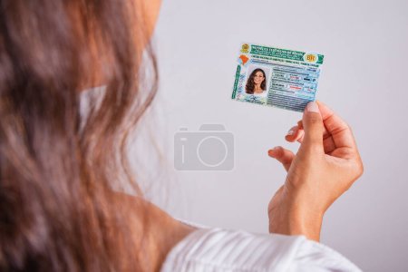 Hand holding driver's license, Brazilian document.