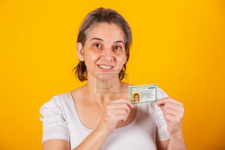 Photo for Adult Brazilian woman holding identity card, RG - Royalty Free Image