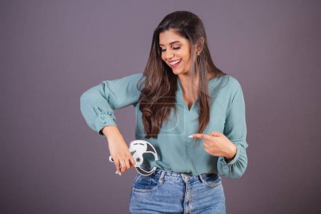 Photo for Horizontal photo. Beautiful Brazilian woman, with casual clothes, Jeans and green shirt. nutritionist holding adipometer. - Royalty Free Image