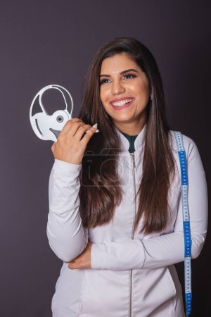 Photo for Horizontal photo. brazilian woman with medical coat, nutritionist. adipometer and measuring tape. slimming. - Royalty Free Image