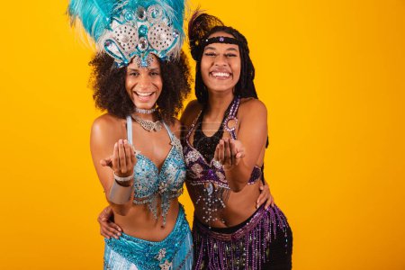 Foto de Dos amigas brasileñas, vestidas de carnaval. invitando a las manos. - Imagen libre de derechos
