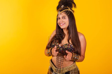 Téléchargez les photos : Belle femme brésilienne en vêtements de carnaval d'or, pointant vers la caméra. - en image libre de droit