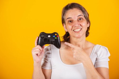 Téléchargez les photos : Femme brésilienne adulte, mère, tenant télécommande de jeu vidéo, joystick. Gamer. Photo en gros plan. - en image libre de droit