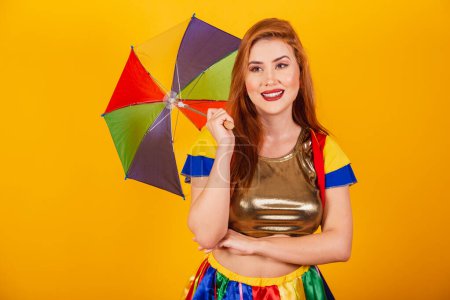 Foto de Pelirroja brasileña, con ropa de carnaval, frevo, y sombrilla de colores. brazos cruzados. - Imagen libre de derechos