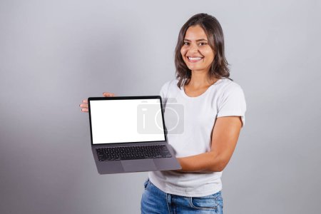 Foto de Mujer brasileña, sosteniendo un cuaderno. Conectado, internet, web, desarrollador. pantalla blanca para anuncios. - Imagen libre de derechos