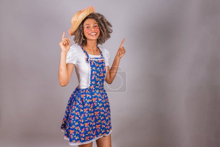 Photo for Young black Brazilian woman, with country clothes, dressed for Festa Junina. Saint John's festival. dancing, partying. - Royalty Free Image