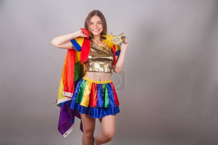 Foto de Mujer rubia brasileña vestida con ropa frevo, carnaval. celebración de máscara de carnaval y bandera lgbt - Imagen libre de derechos