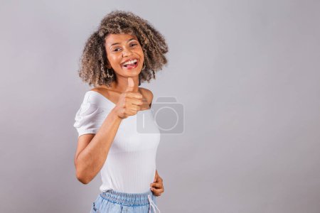 Foto de Hermosa mujer brasileña negra, ropa casual, pulgar hacia arriba, como, retroalimentación positiva. - Imagen libre de derechos