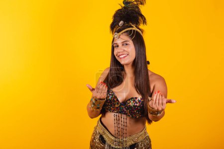 Foto de Hermosa mujer brasileña en ropa de carnaval de oro invitando y llamando con las manos - Imagen libre de derechos