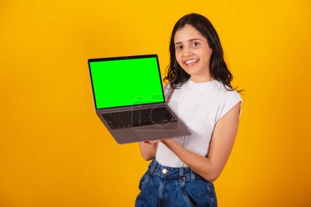 Foto de Hermosa mujer brasileña sosteniendo portátil, mostrando pantalla verde. - Imagen libre de derechos
