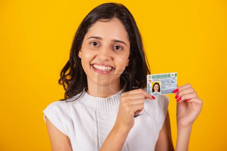 Photo for Beautiful brazilian woman holding driver's license document. - Royalty Free Image