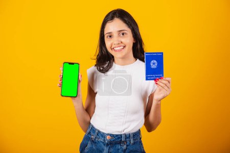 Foto de Hermosa mujer brasileña sosteniendo tarjeta de trabajo y teléfono celular con pantalla verde. - Imagen libre de derechos
