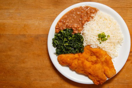 Photo for Delicious breaded chicken dish with rice, beans and cabbage - Royalty Free Image