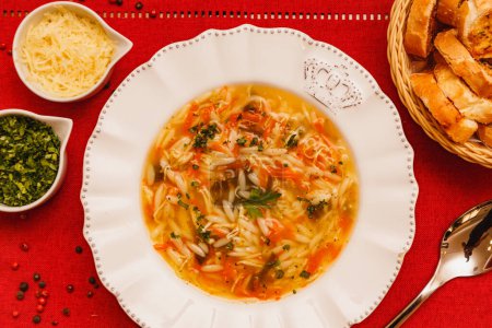 Foto de Deliciosa sopa de pollo tradicional con mandioca, pollo, papas y arroz, gastronomía y comida de invierno - Imagen libre de derechos