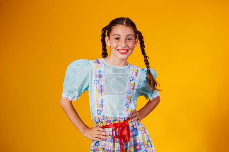Foto de Niño en ropa típica de la famosa fiesta brasileña llamada Festa Junina en celebración de So Joo. Hermosa chica sobre fondo amarillo. - Imagen libre de derechos