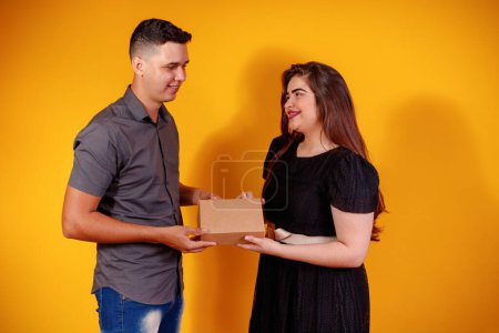 Téléchargez les photos : Jeune couple de Saint-Valentin avec boîte de bonbons faisant surprise. Concept de cadeaux et de valentines. - en image libre de droit