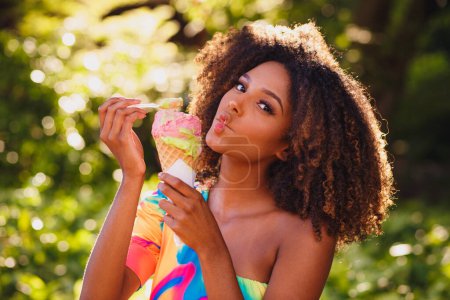 Photo for Happy afro woman eating ice cream in the park. - Royalty Free Image