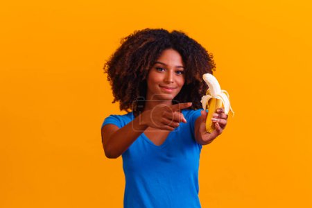 Foto de Una joven afro comiendo plátano. Concepto de salud. Alimentación saludable - Imagen libre de derechos